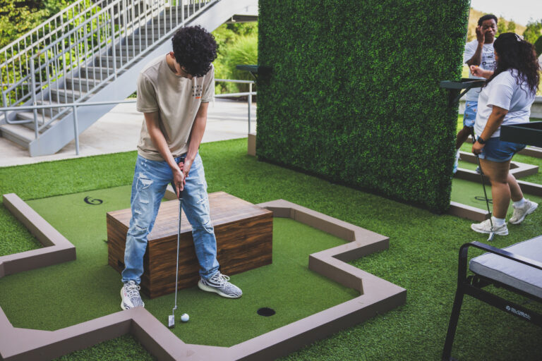 Immerse yourself in an artistic oasis at Drive Shack, featuring Puttery's outdoor art garden mini golf course.